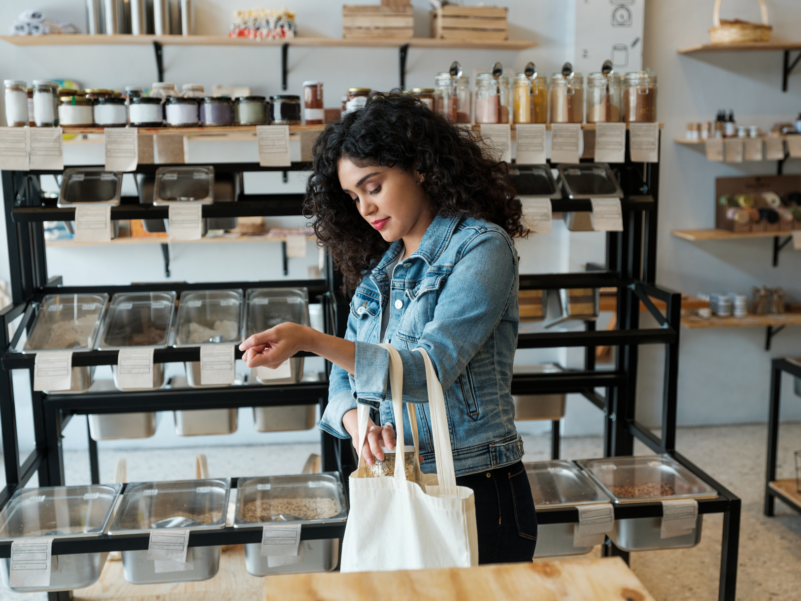 Young woman using reusable shopping bag in store